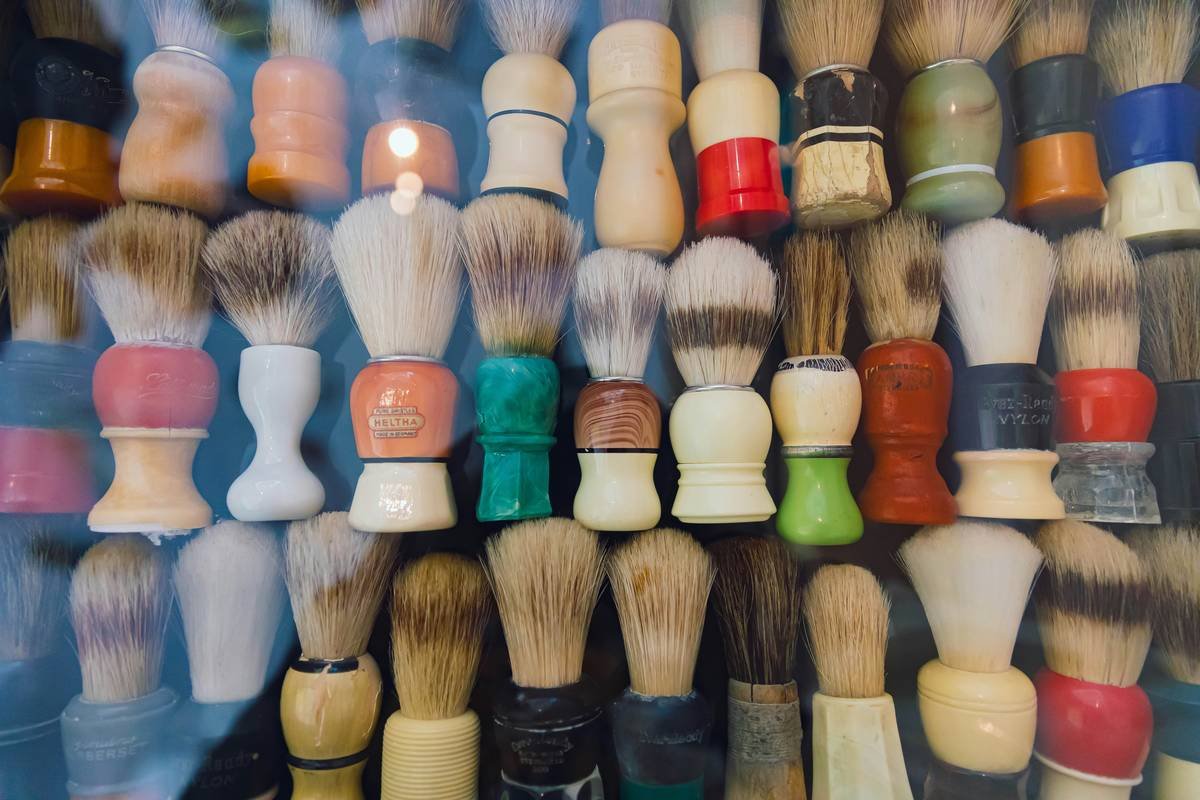 Side-by-side microscope comparison showing smooth synthetic fibers vs. barbed natural bristles