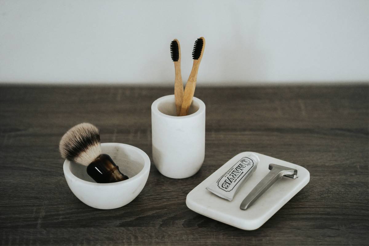 Close-up of premium shaving brushes creating rich lather in a ceramic bowl