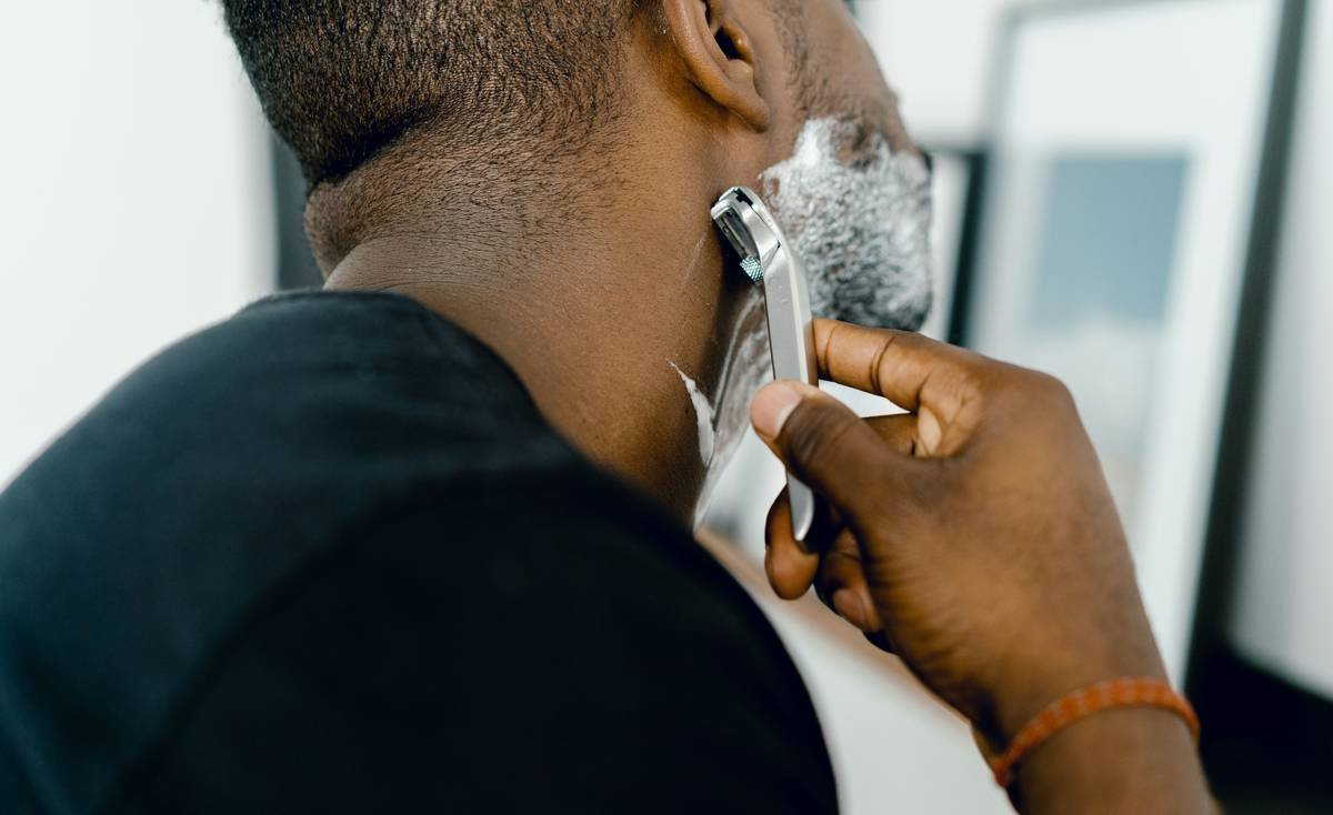 Man using grooming supplies for beard shaping with shaving brush applying lather before trim